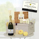 Pampering Treat Box with Personalised Champagne. A luxury gift arrangement featuring a bottle of personalised Champagne, two flutes filled with champagne, and a decorative gift box. The box contains various treats along with scented candles. Yellow bath bombs are placed on the surface alongside the items, all set against a light background that suggests a sophisticated atmosphere. Pampering Treat Box with Personalised Champagne. A luxury gift arrangement featuring a bottle of personalised Champagne, two flutes filled with champagne, and a decorative gift box. The box contains various treats along with scented candles. Yellow bath bombs are placed on the surface alongside the items, all set against a light background that suggests a sophisticated atmosphere.
